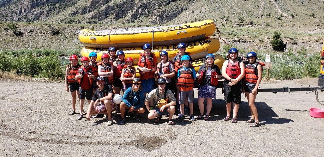 A 4-H club poses in front of a whitewater raft